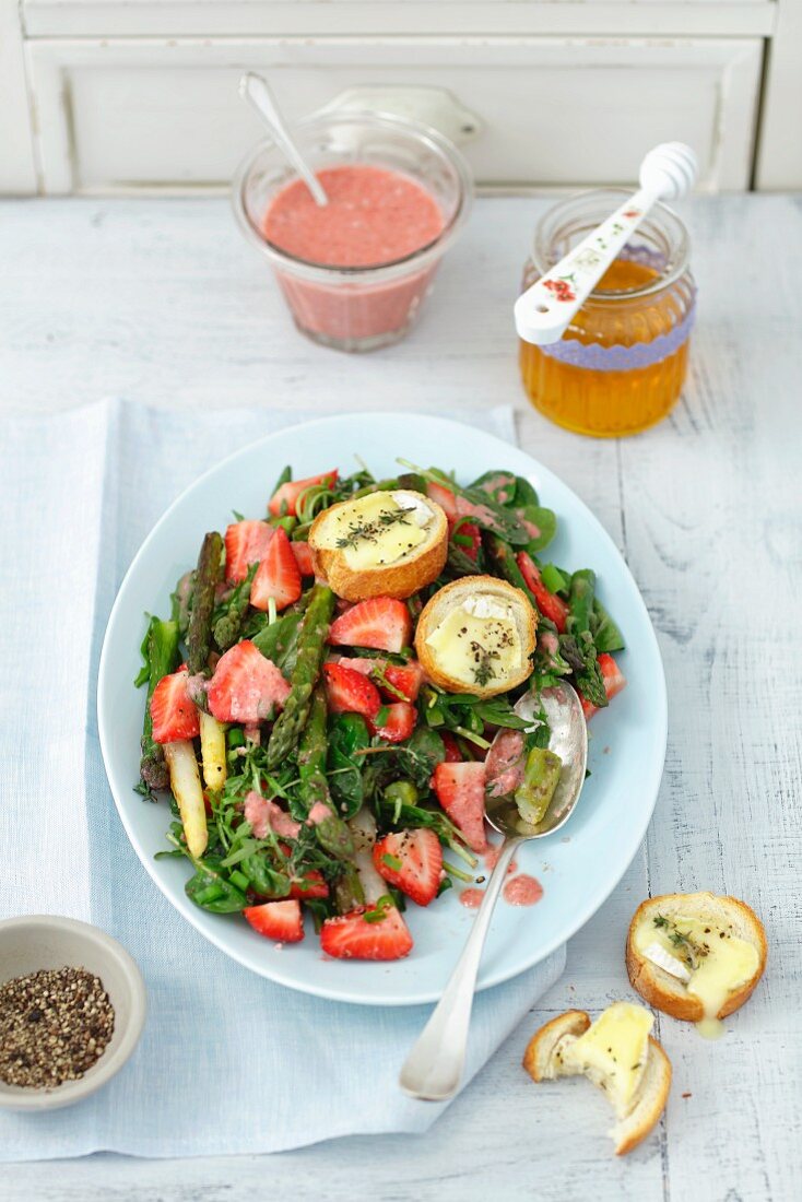 Spinach salad with strawberries, green asparagus, goat's cheese croutons and strawberry sauce