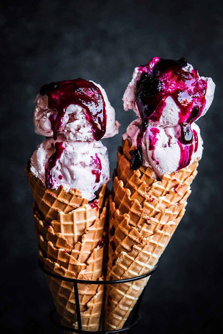 Strawberry ice-cream with blueberry compote in ice cream cones