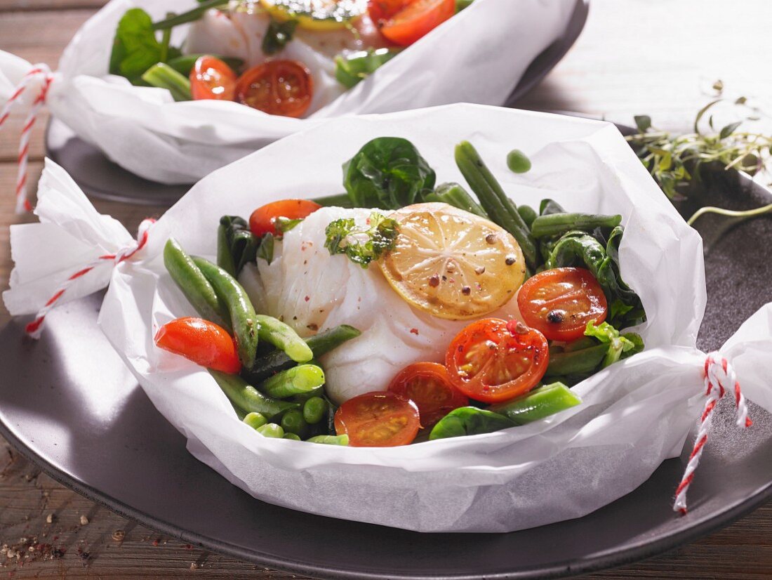 Cod with vegetables and lemons in parchment paper