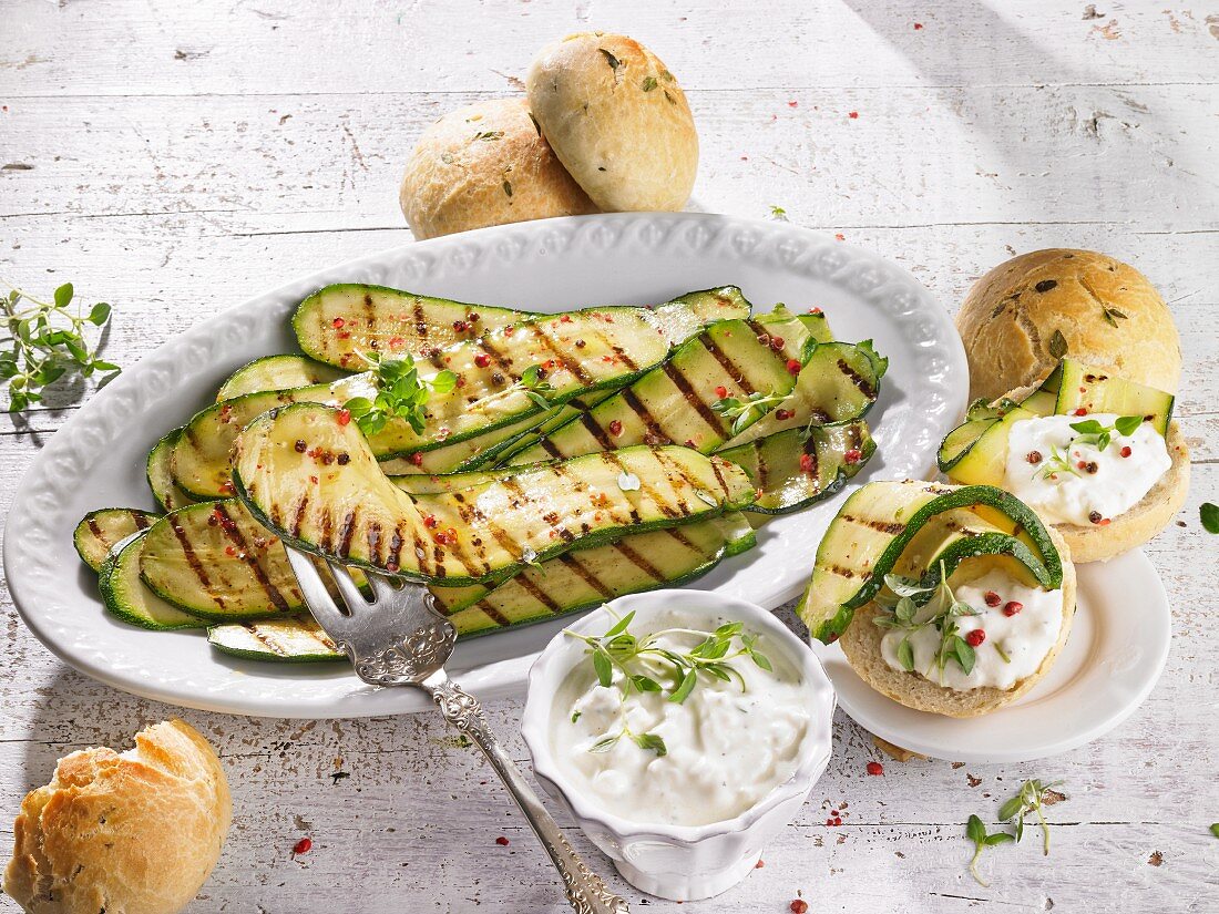 Marinated grilled courgettes with a sheep's cheese sauce and bread rolls