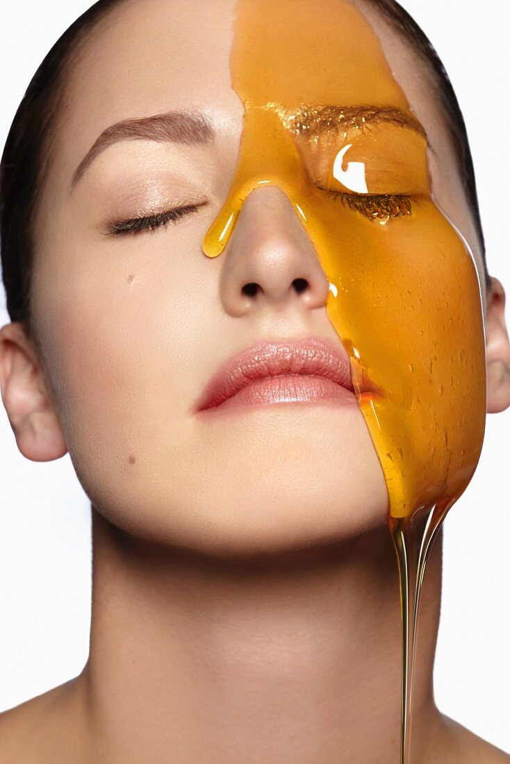 Honey flowing over a woman's face