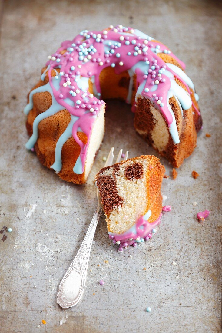 Marble cake with colourful icing and sugar sprinkles