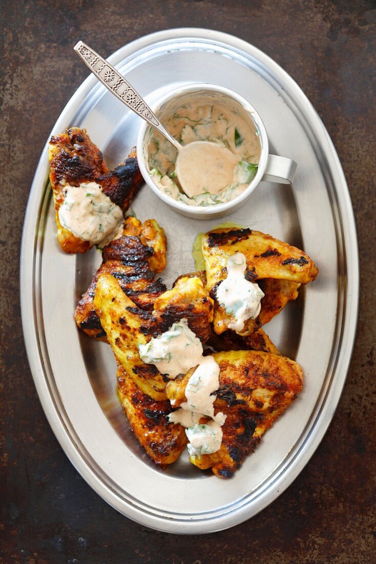 Grilled chicken wings marinated in yoghurt and curry with a yoghurt and coriander dip
