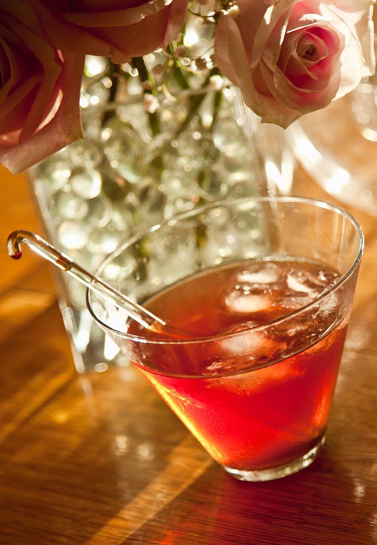 A Manhattan cocktail with roses in a crystal vase