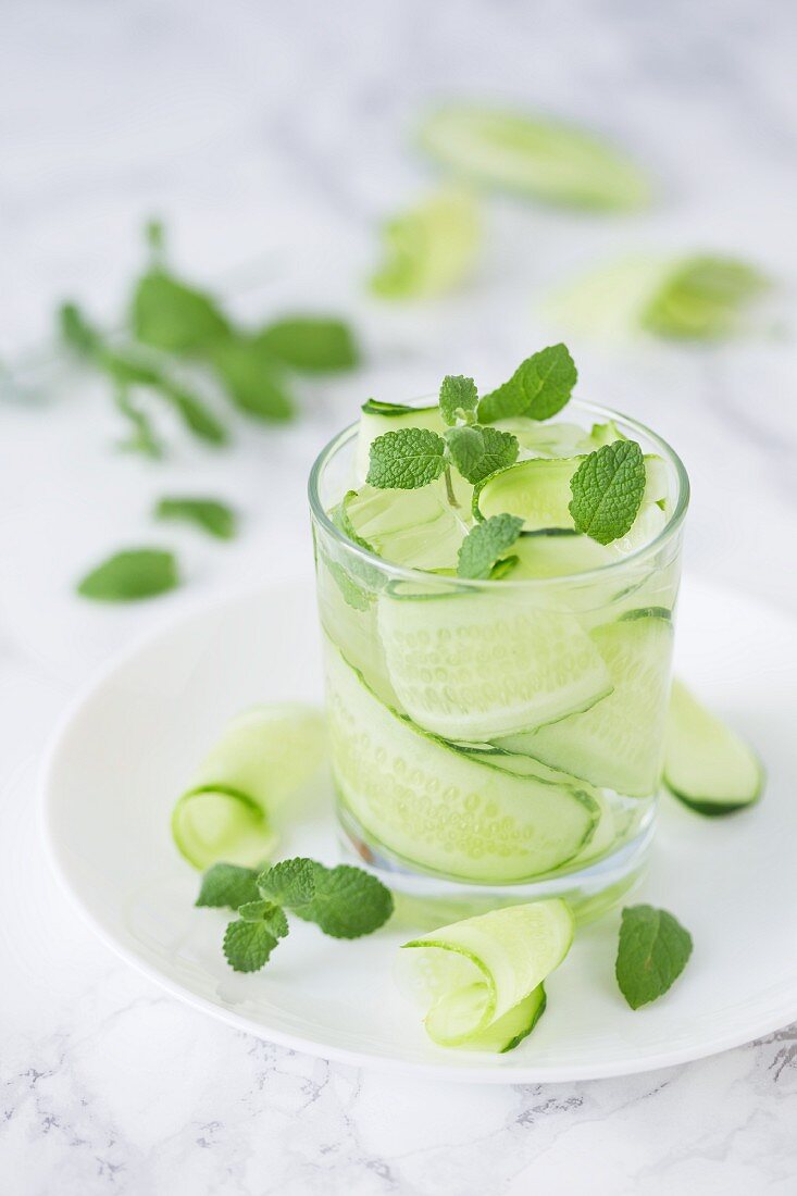 Wasser mit Gurkenstreifen, frischer Minze und Eiswürfeln