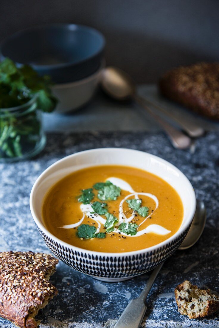Sweet potato soup with yoghurt and coriander and a fresh seeded bread next to it
