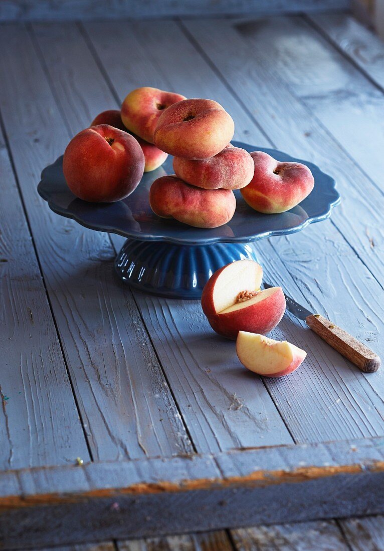 Vineyard peaches and a white peach on a cake stand