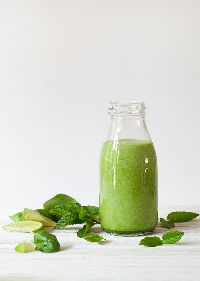 Eine Flasche Spinatsmoothie mit Minze und Limette