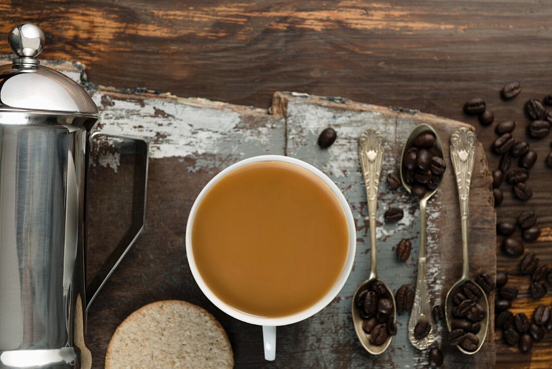 An arrangement of coffee featuring biscuits, coffee beans and a coffee jug