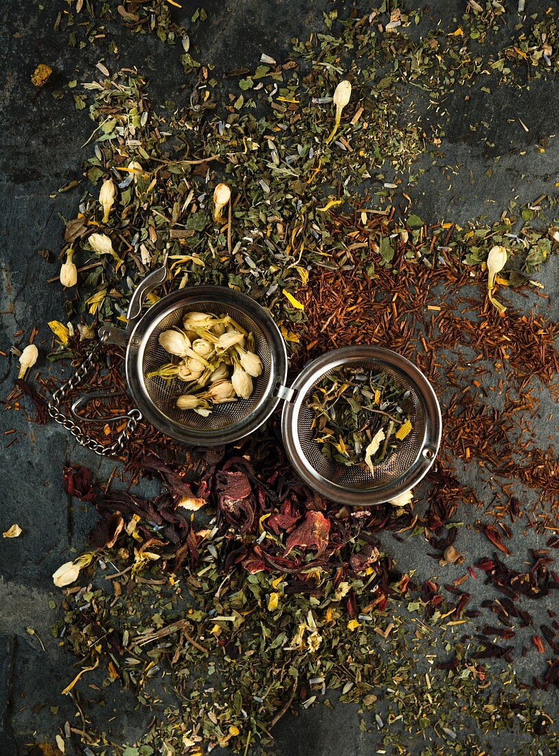 Various types of herb tea scattered on a wooden surface