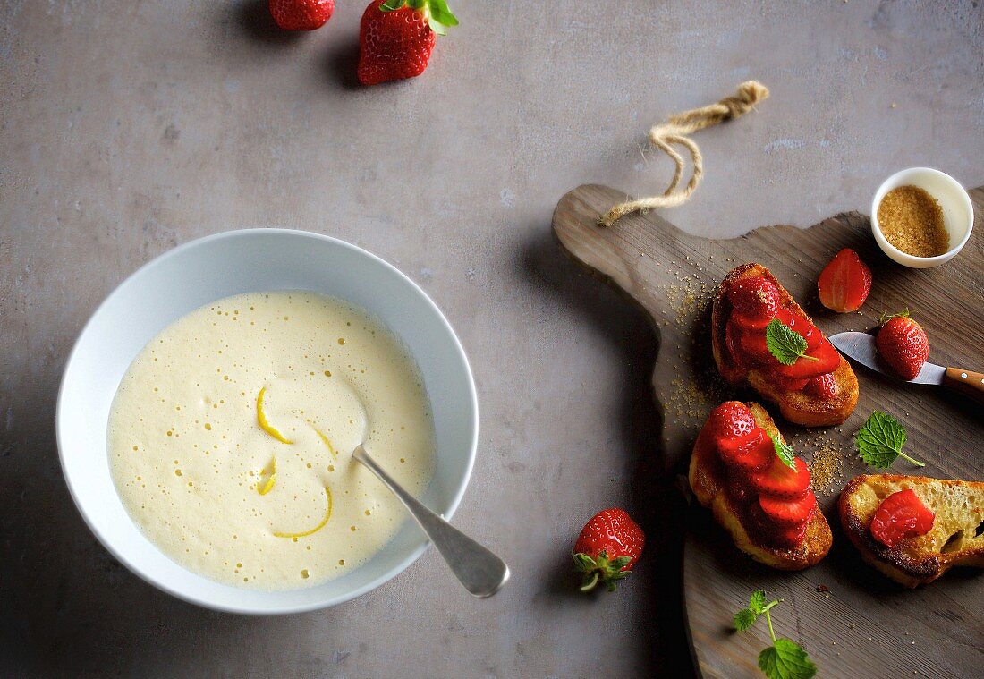 Foamy white beer soup with lemon served with sweet bruschetta with strawberries