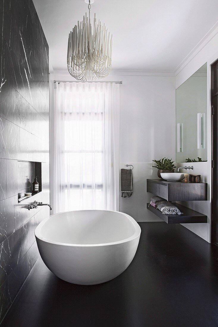 Elegant, free-standing bathtub in the bathroom with black floor