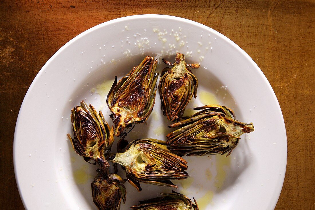 Grilled artichokes on a plate with salt