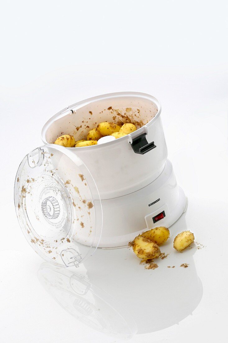 Elektrische Kartoffelschälmaschine vor weißem Hintergrund