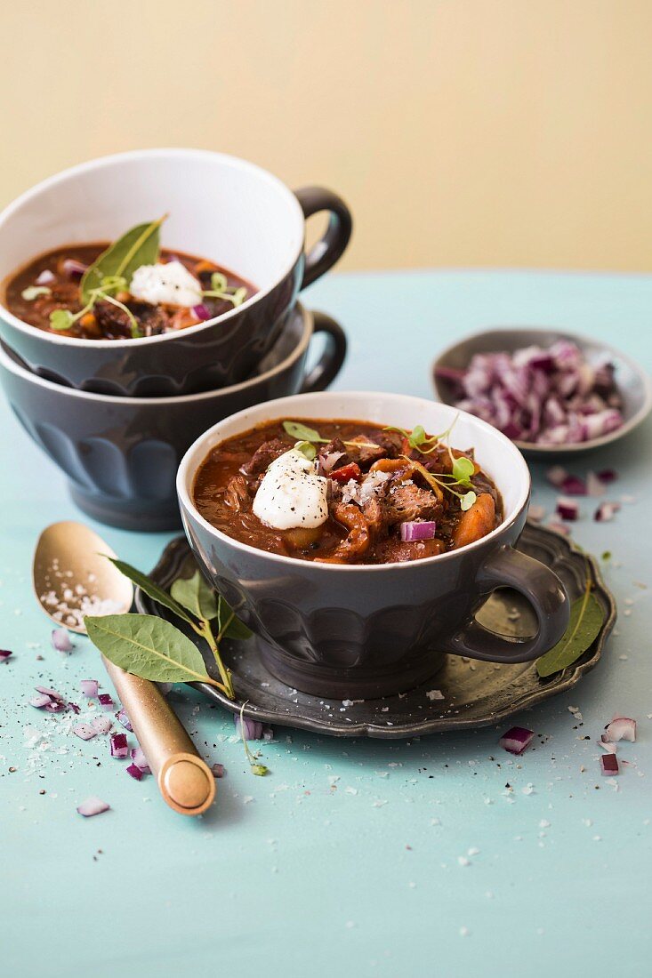 Gulaschsuppe mit Nudeln, Paprika, roten Zwiebeln und Sauerrahm