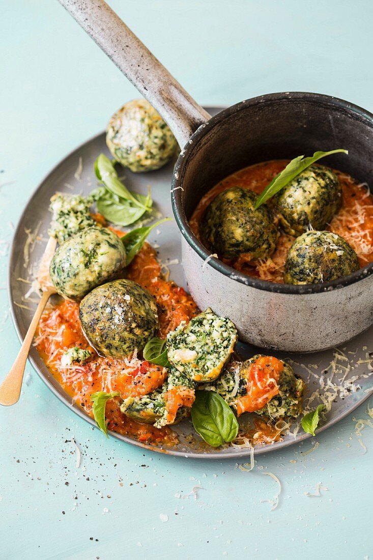 Gnudi (ricotta dumplings) with spinach and basil on tomato sugo