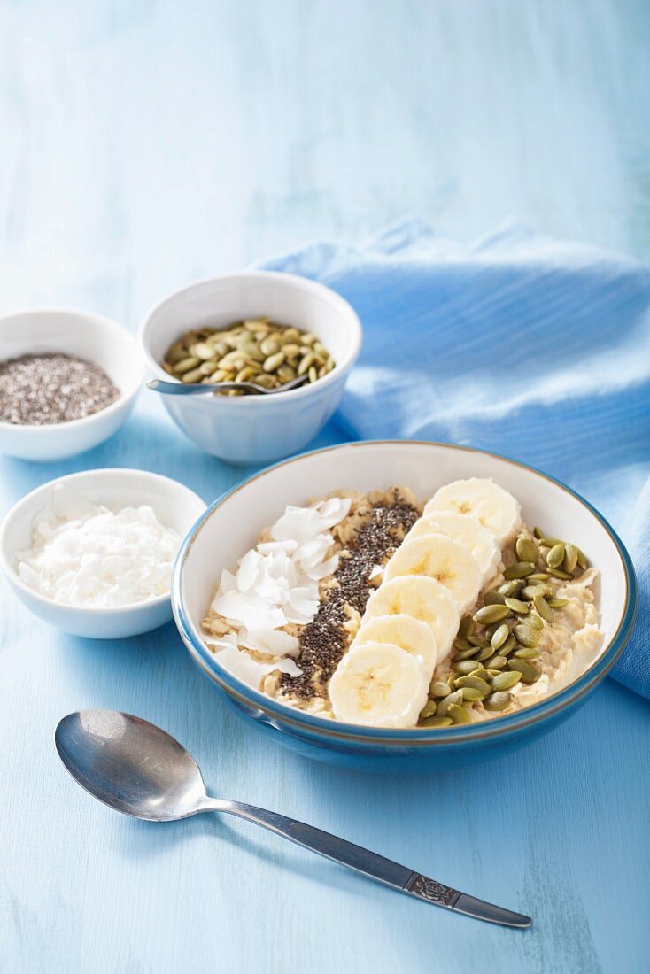 Porridge mit Bananen, Kürbiskernen, Chiasamen und Kokosflocken