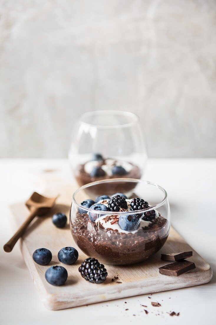 Schokoladen-Chia-Pudding mit Joghurt und Beeren in einer Glasschale
