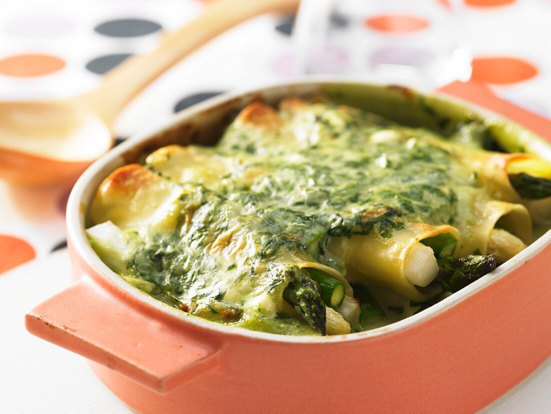 Asparagus cannelloni covered in cheesy spinach sauce