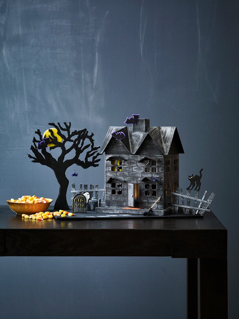 Gespenstisches Deko-Häuschen mit Baum, Grab und schwarzer Katze als Halloweendeko