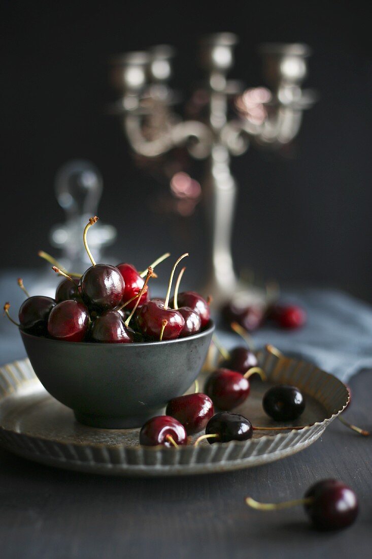 Cherries in a bowl on a metal plate