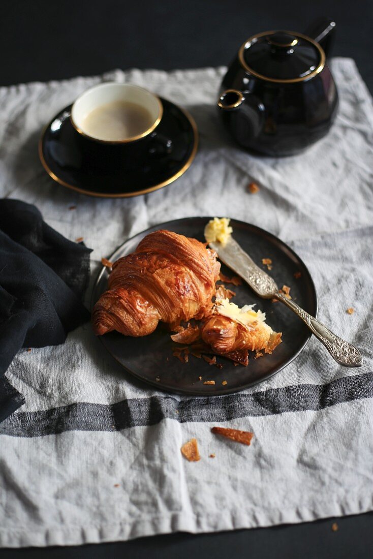 A croissant and black coffee
