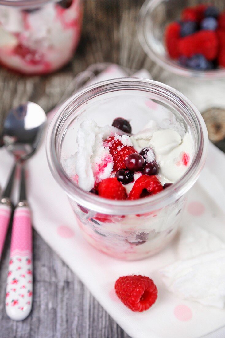 Pavlova with berries in a glass jar