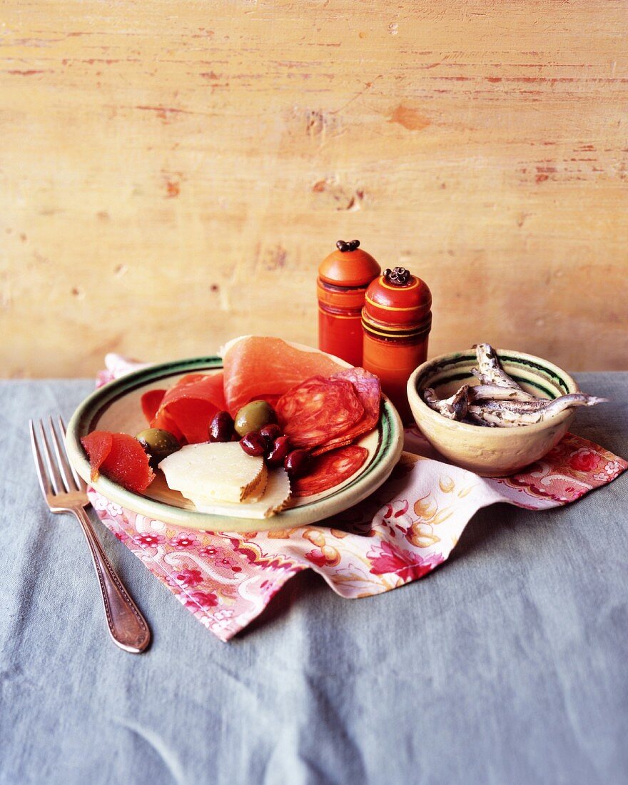 Antipasti-Teller mit Wurst, Schinken, Käse, Oliven und Sardinen