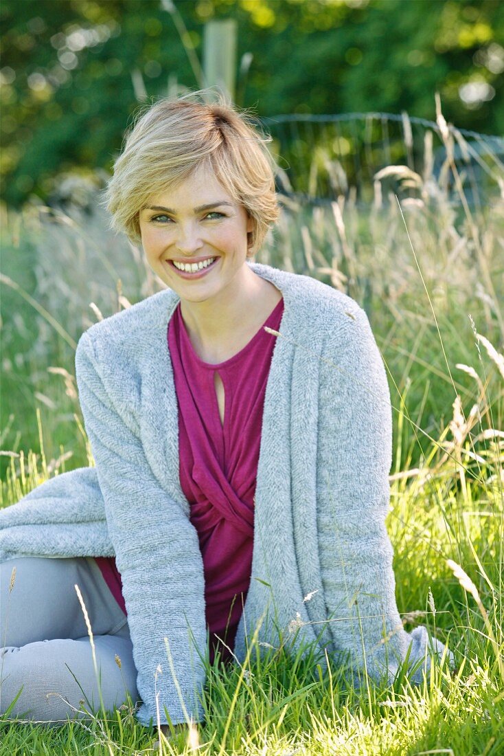 A young woman wearing a top and a fluffy cardigan