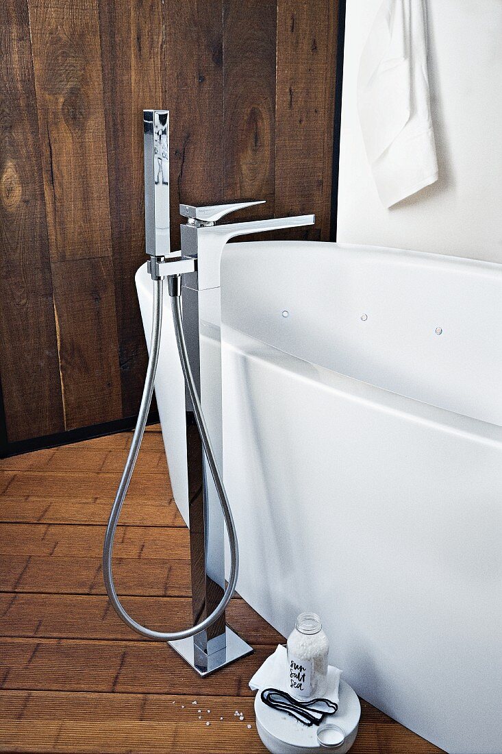 A freestanding white bath with an elegant standing tap