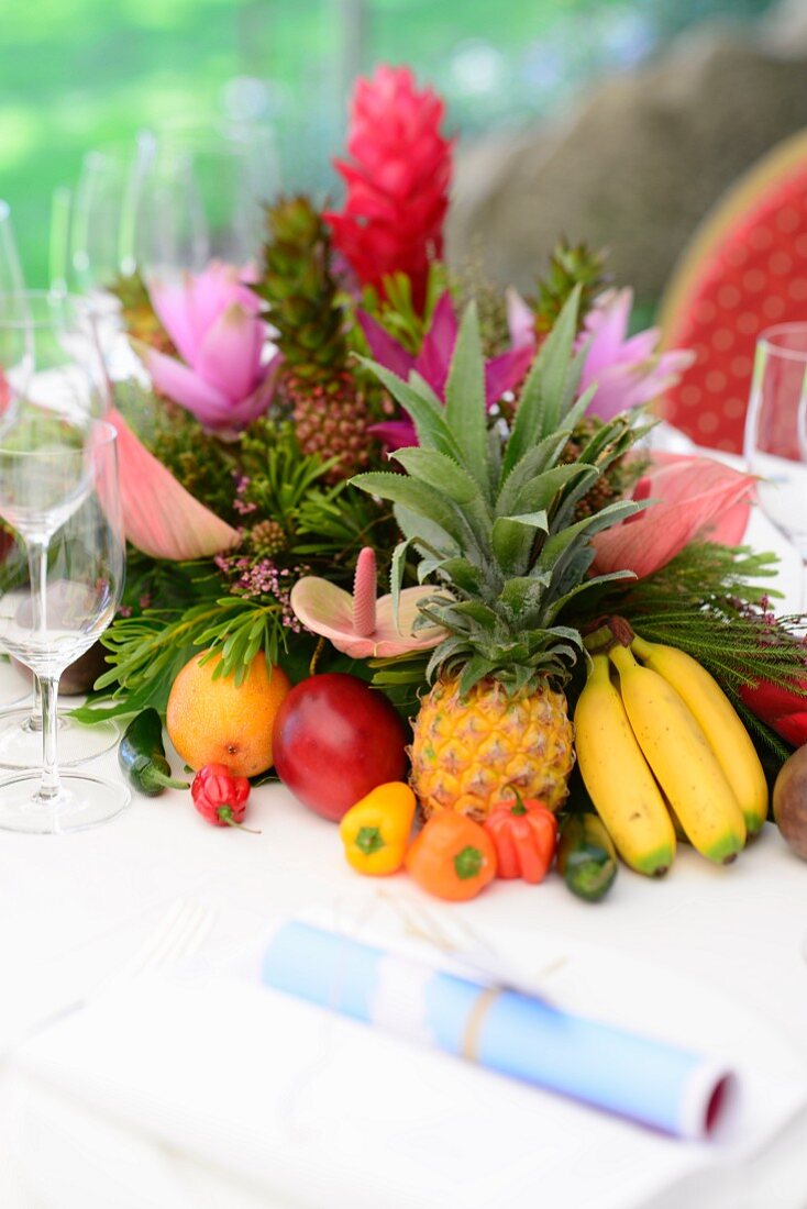 Exotische Früchtedeko mit Blumen als Tischdeko zum karibischen Buffet