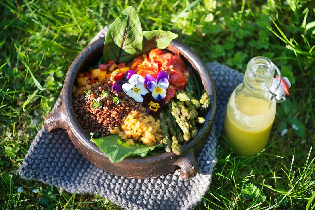 A salad with lentils, red quinoa, green asparagus, tomatoes, pepper and sorrel dressing