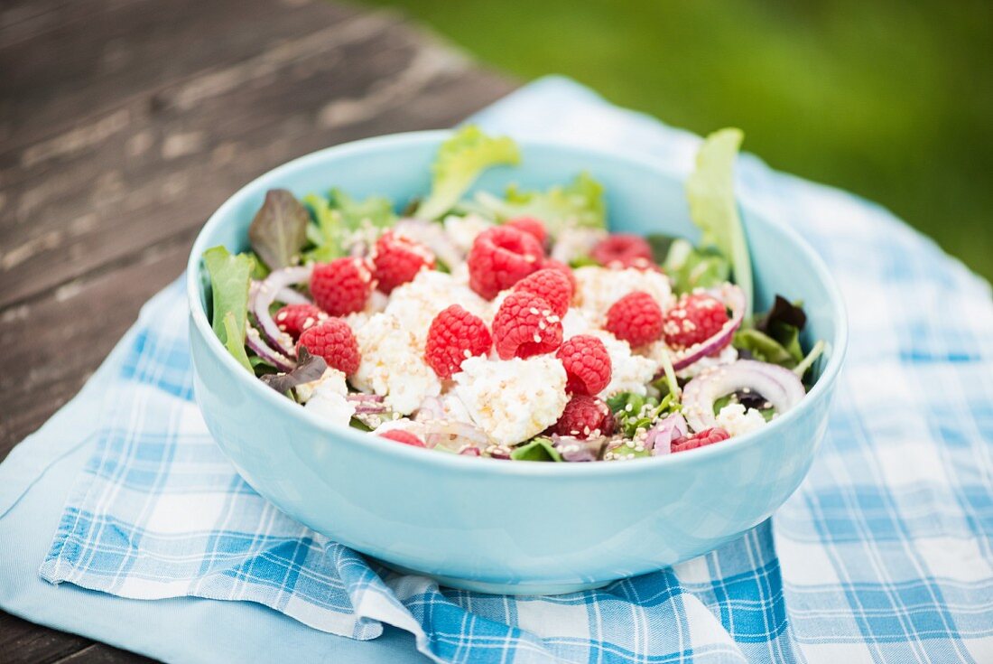 Salad with goats' cream cheese, raspberries and sesame seeds