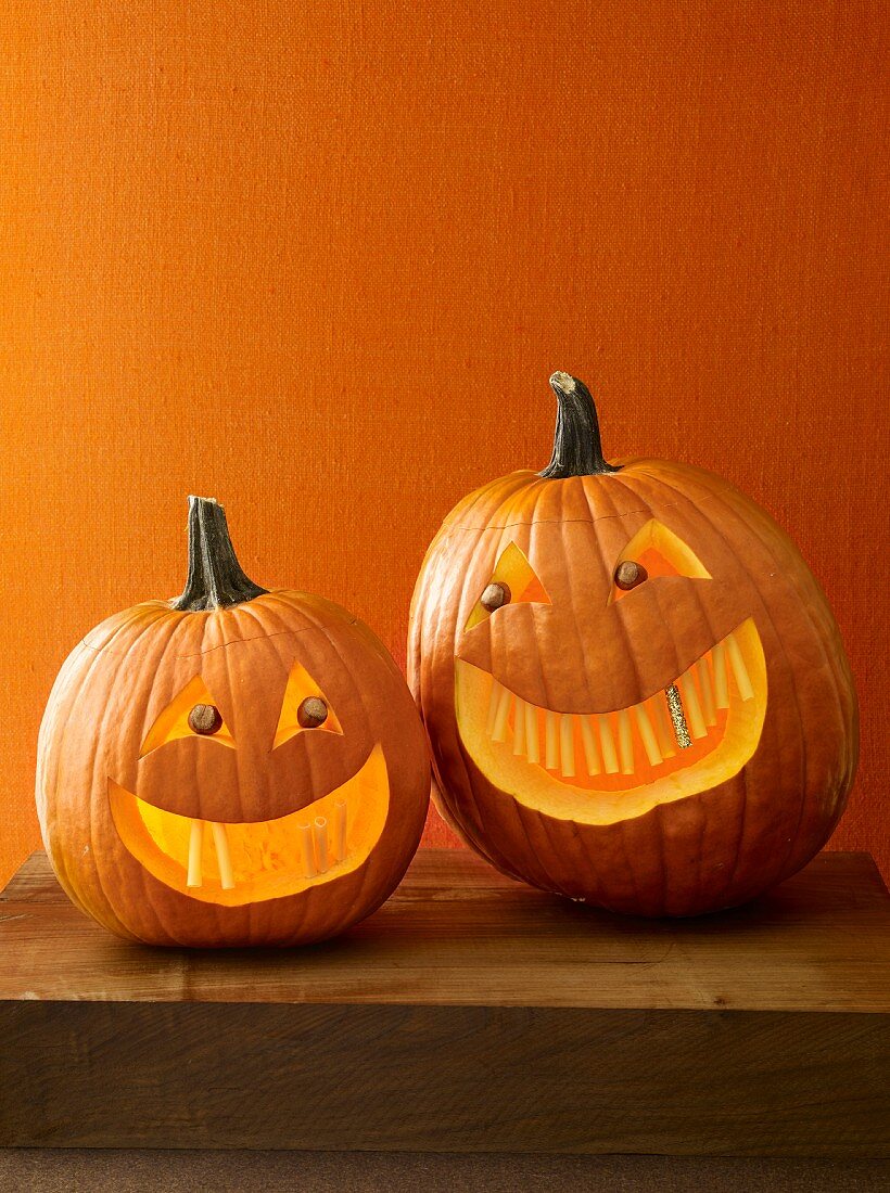 Two Halloween pumpkins with scary faces