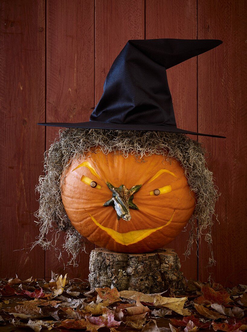 A Halloween pumpkin with a witch's face and a witch's hat