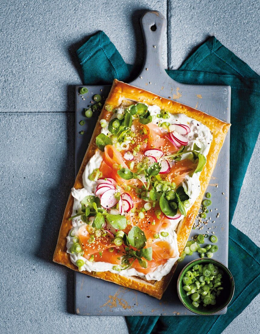 A puff pastry tart with fresh cheese, smoked salmon, wasabi and spring onions