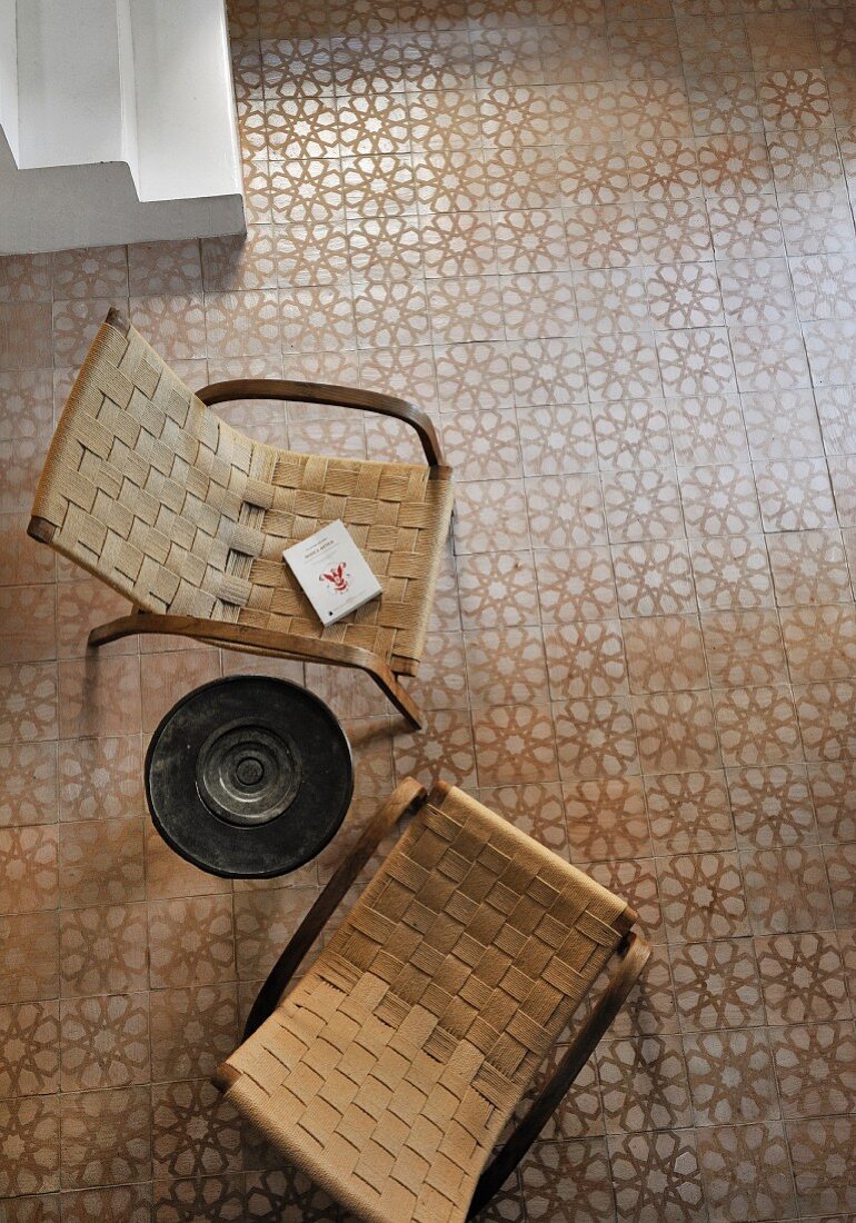 Two retro armchair with woven seats on tiled floor