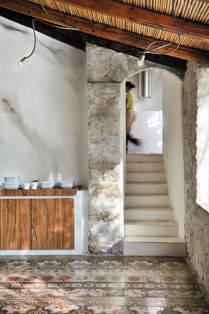 Stairway with arched entrance and traditional tiled floor in Mediterranean building