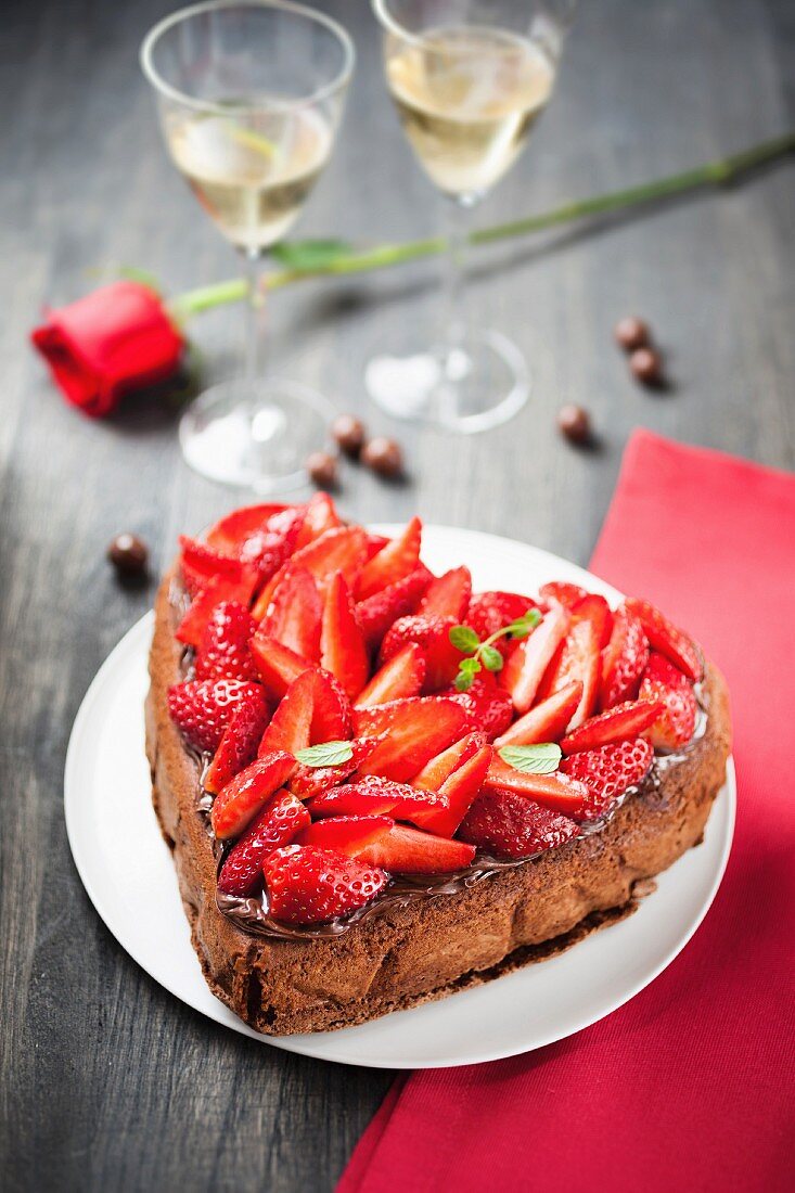 A heart-shaped chocolate cake decorated with strawberries