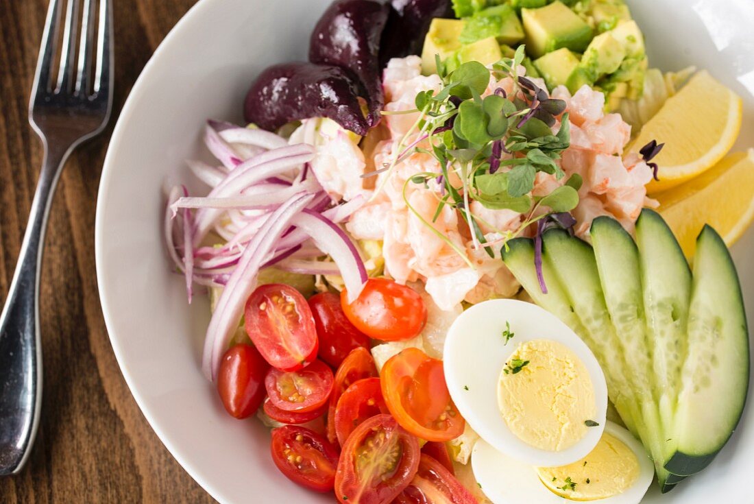 A vegetable salad with shrimps and hard-boiled eggs