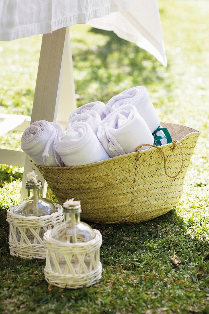 Oil lamps and rolled blankets for guests in raffia basket