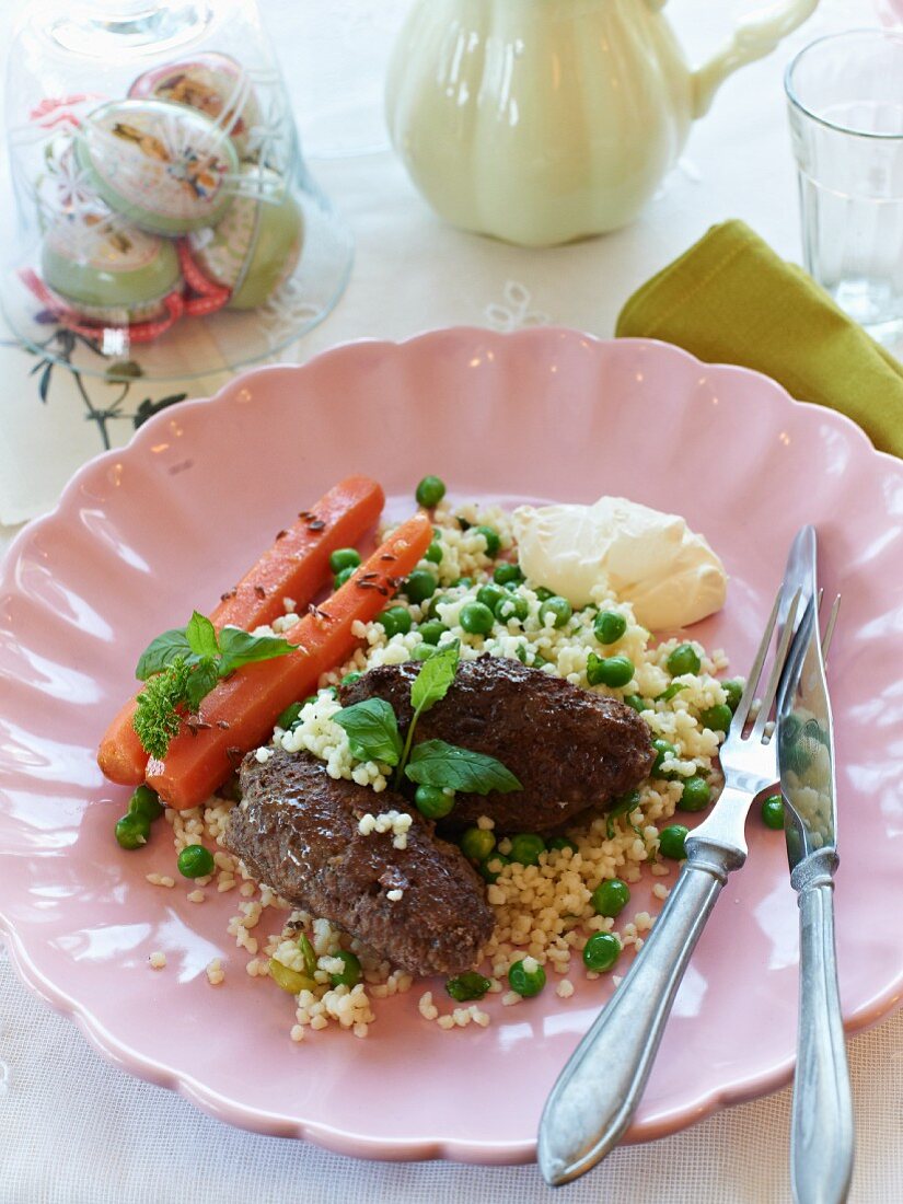 Lammhackbällchen auf Couscous mit Erbsen, Minze und Joghurt