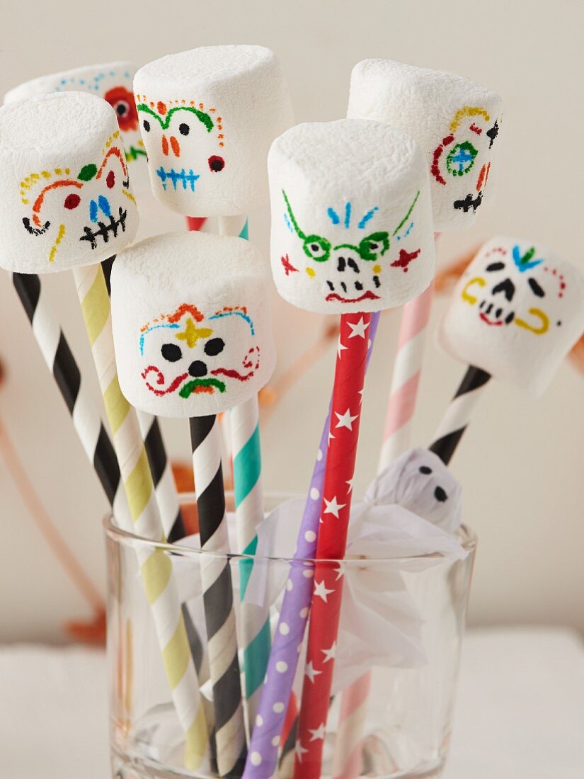 Marshmallows with spooky painted faces on straws
