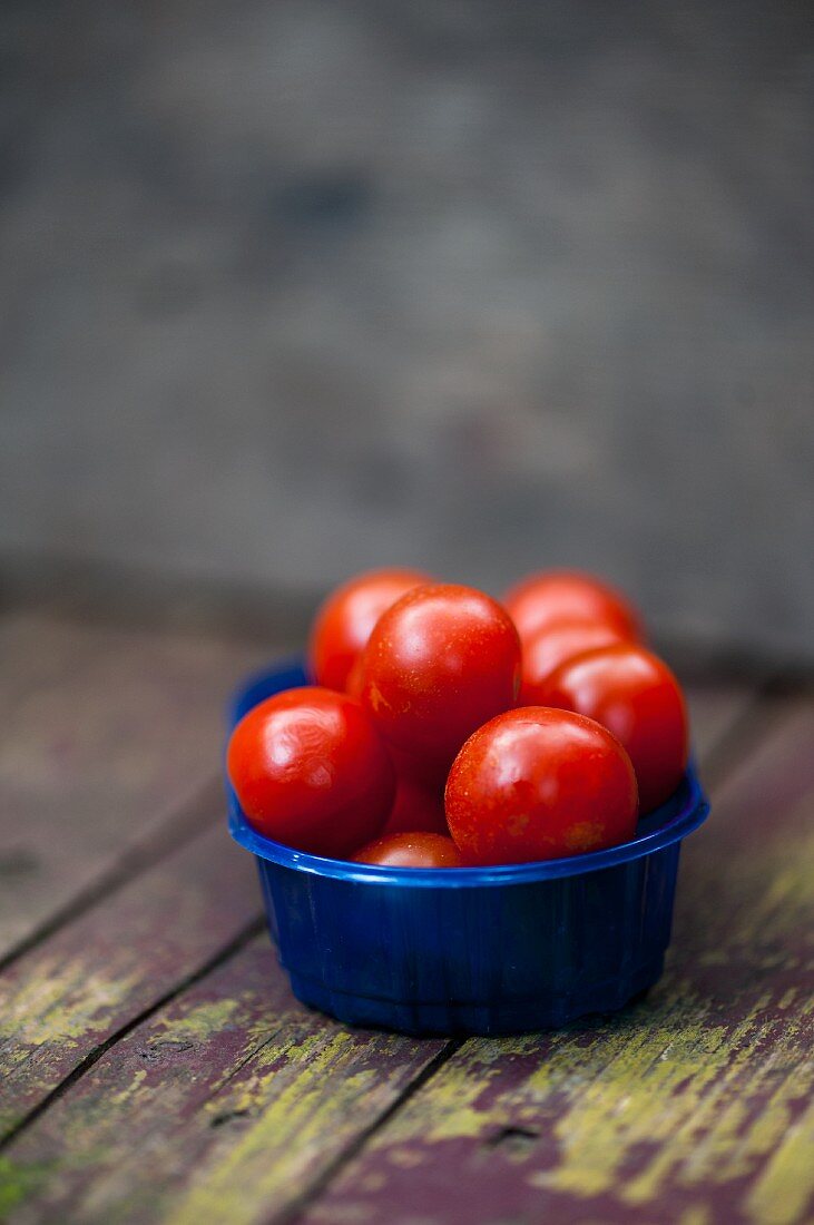 Cocktail tomatoes in a blue plastic bowl