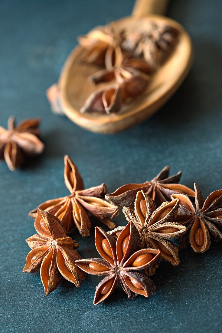 Star anise on a spoon and on a slate surface