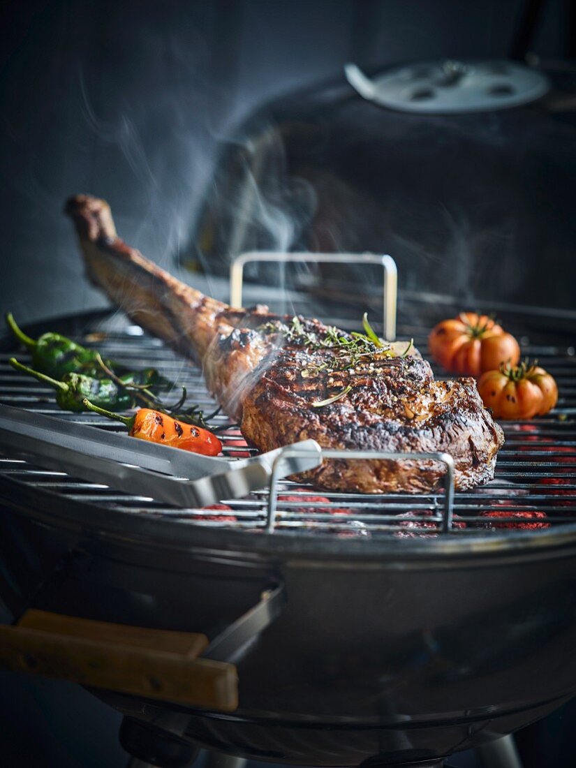 Tomahawk steak on a kettle barbecue