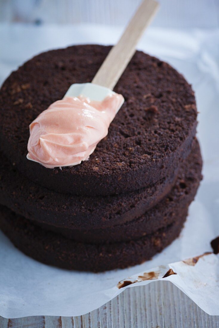 Schokoladenkuchen zubereiten: Tortenböden mit Erdbeercreme bestreichen