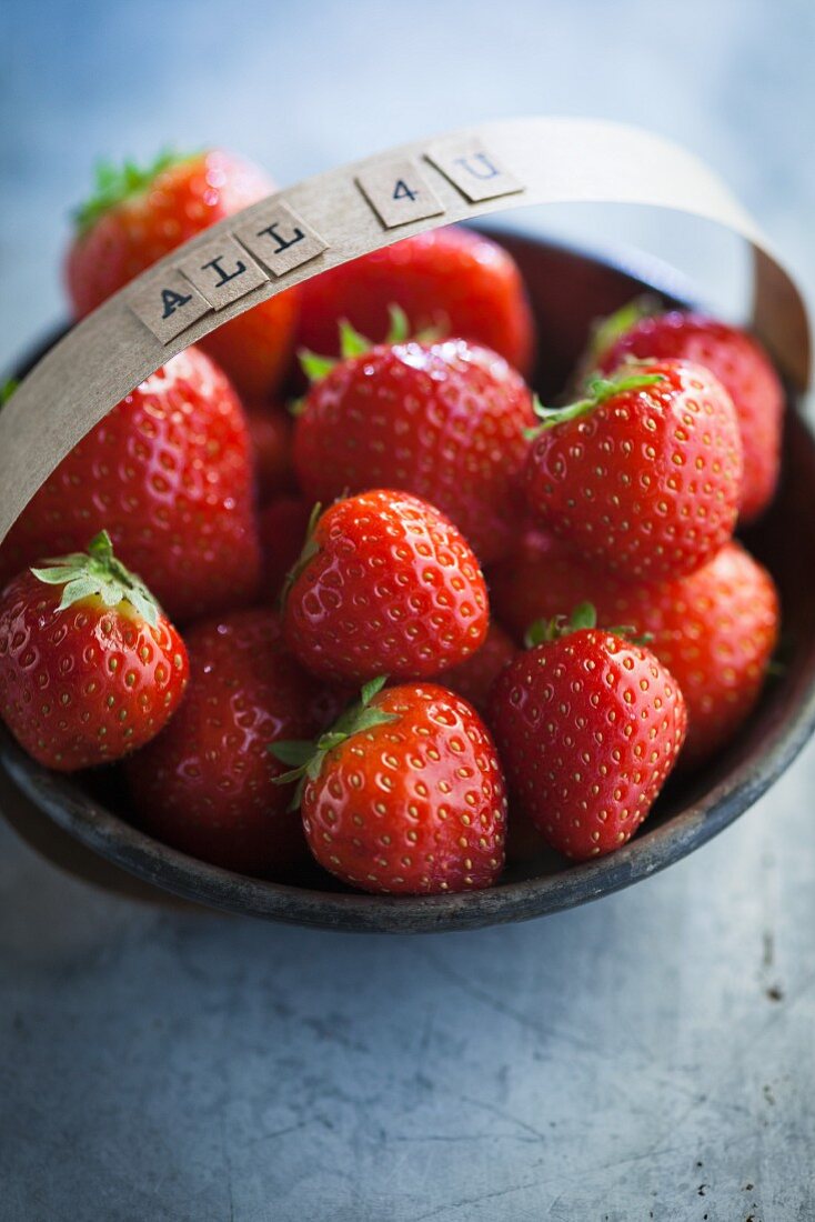 Strawberries in a bowl with the words 'All 4 U' on the handle