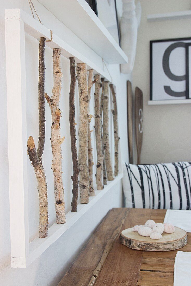 3D artwork made from birch branches above rustic wooden table