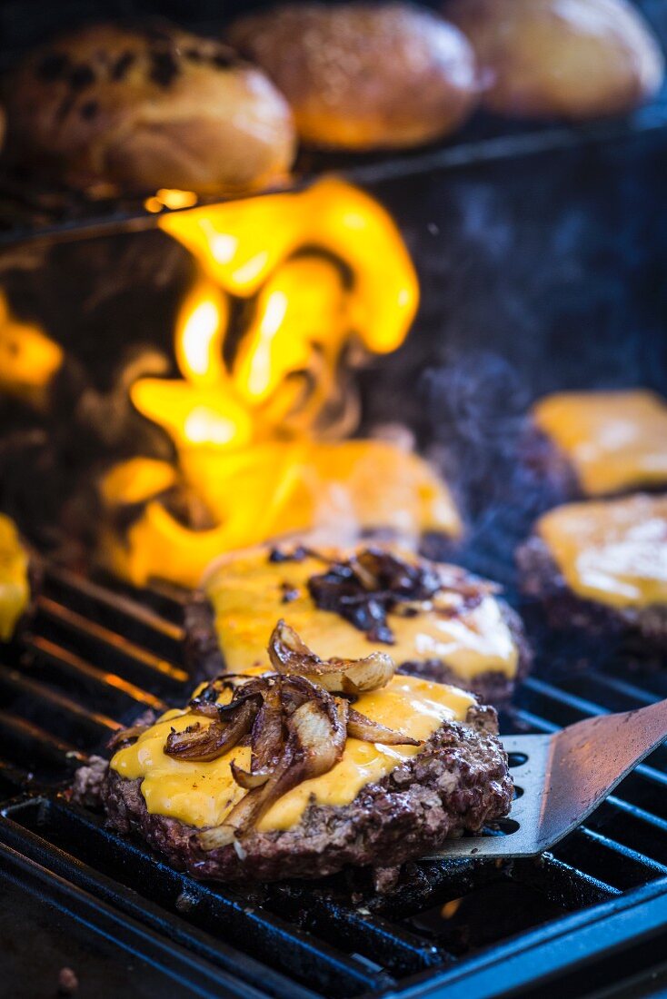 Cheeseburgers with fried onions on the barbecue